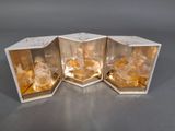 trois boîtes contenant du verre de couleur dorée