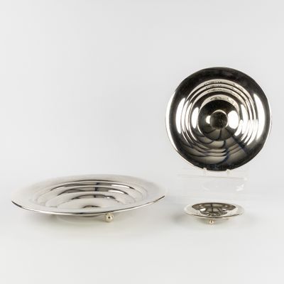 une assiette en argent et une assiette en argent posées sur une surface blanche