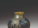 a blue and yellow vase sitting on a white surface