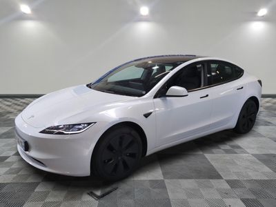 a white tesla model s is parked on a checkered floor