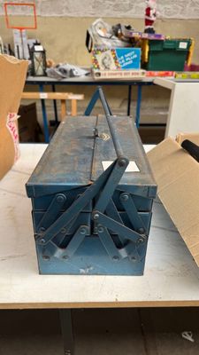 une boîte à outils bleue posée sur une table dans un atelier