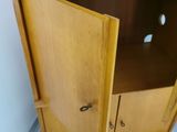 a wooden cabinet with a door open in a room