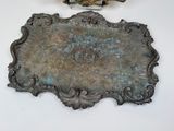 a silver plate with a bird on it next to a pair of scissors