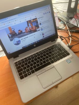 a laptop computer sitting on top of a wooden desk