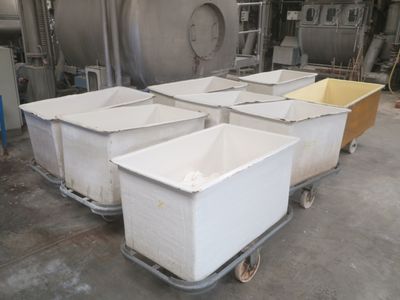 four bins sitting on a dolly in a factory