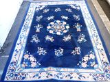 un tapis bleu posé à même le sol devant un immeuble