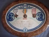 une photo d'une plaque sur laquelle figurent des médailles et un certificat