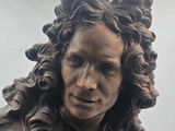 a statue of a woman with long hair and a flower in her hair