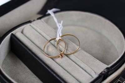 two gold rings in a black case with a white string