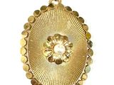 an image of a gold pendant with a flower in the center