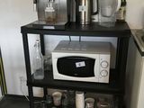 a microwave and a coffee maker on a shelf in a kitchen