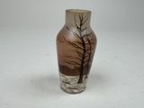 a glass vase with a tree on it sitting on a table