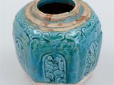 a small blue vase with a decorative design on it