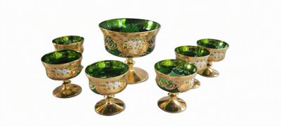 un ensemble de verres à pied et de tasses en verre vert posés sur une table