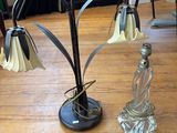 une table sur laquelle se trouvent une lampe et une bouteille en verre