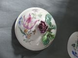 a white plate with a flower on it next to a plate with a flower on it