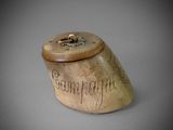 a wooden box with writing on it on a gray surface