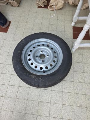 un pneu posé par terre à côté d'une chaise dans une pièce