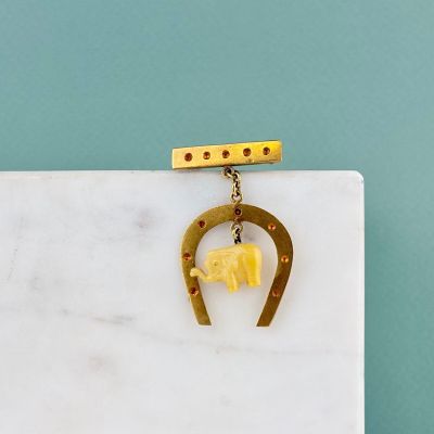 dalle de marbre sur laquelle sont représentés un fer à cheval doré et un éléphant jaune