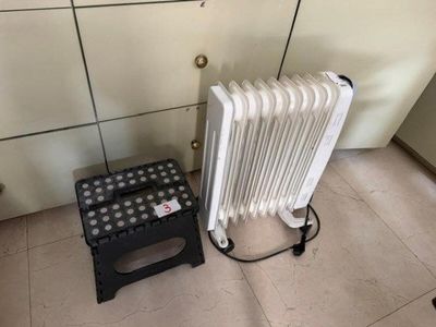 un radiateur et un tabouret dans un coin de la pièce