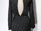 the back of a black dress with white polka dots on it