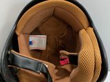 a helmet that is sitting on the floor next to a bag
