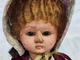 a close up of a doll with a hat on