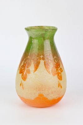 a green and orange vase sitting on a white surface