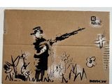 une boîte en carton sur laquelle figure l'image d'un homme tenant un pistolet