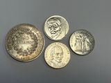 quatre pièces de monnaie britanniques différentes posées les unes à côté des autres sur une table