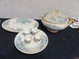 a blue and white dinner set on a black table