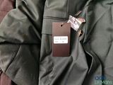 a tag on a jacket that is laying on a bed