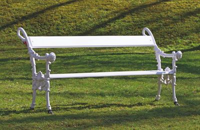 un banc blanc posé au milieu de la pelouse