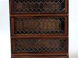 an old wooden bookcase with glass doors on top of it