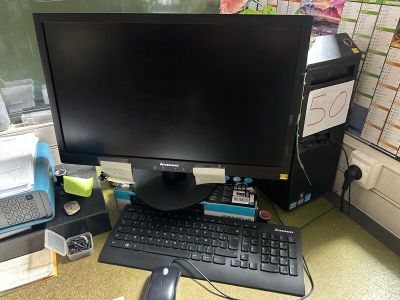 un écran d'ordinateur posé sur un bureau, à côté d'un clavier et d'une souris