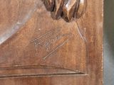 sculpture of a man with long hair and a beard on a wooden plaque