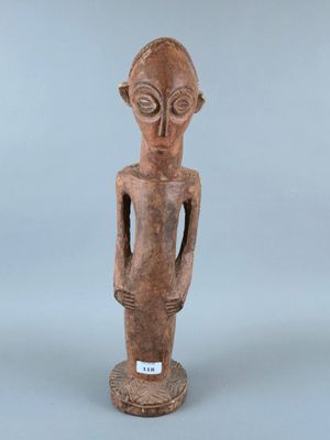 une statue en bois représentant un homme dont le visage et les mains sont posés sur sa poitrine