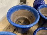 three blue vases sitting on a pallet next to each other