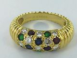 an image of a gold ring with multi colored stones on it