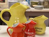 three pitchers sitting on a table next to each other