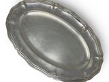 a silver plate with a decorative edge on a white background