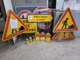 de nombreux panneaux de chantier posés au sol à côté d'un immeuble