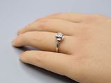 une main de femme portant une bague en diamant