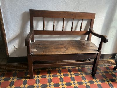 a wooden bench that is sitting on a tiled floor
