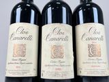 three bottles of red wine sitting on top of a white table