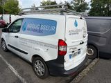 a white van parked in a parking lot next to other cars