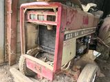 a red tractor that is sitting in the dirt