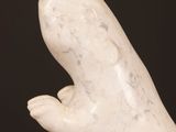 sculpture of a hand holding something in the air on a black background