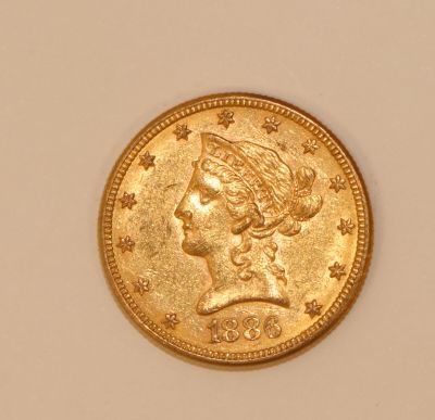 a close up of a gold coin with a woman ' s head on it