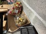 a box full of christmas balls on the ground next to a wall